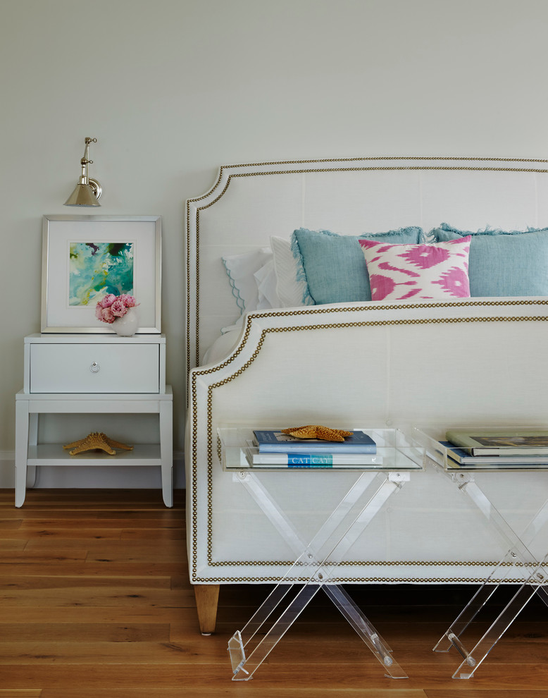 Ejemplo de dormitorio costero sin chimenea con paredes beige y suelo de madera en tonos medios
