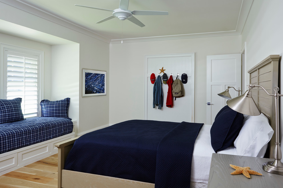 Diseño de dormitorio marinero de tamaño medio sin chimenea con paredes beige y suelo de madera en tonos medios