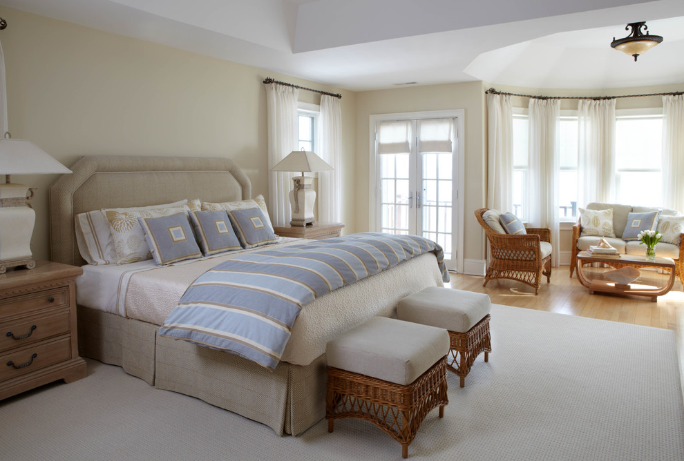 Imagen de dormitorio principal tradicional grande sin chimenea con suelo de madera clara y paredes beige