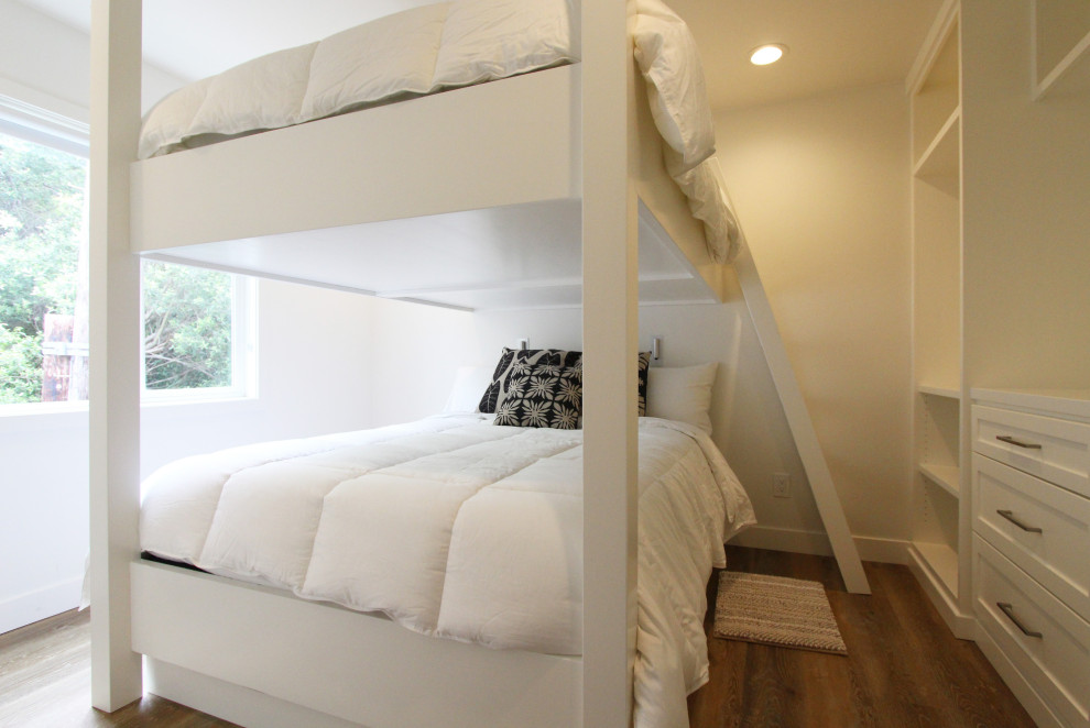 Modelo de dormitorio principal marinero de tamaño medio con paredes blancas, suelo vinílico y suelo marrón
