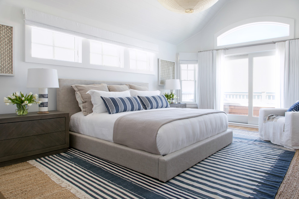 Großes Maritimes Hauptschlafzimmer ohne Kamin mit weißer Wandfarbe, braunem Holzboden und braunem Boden in New York