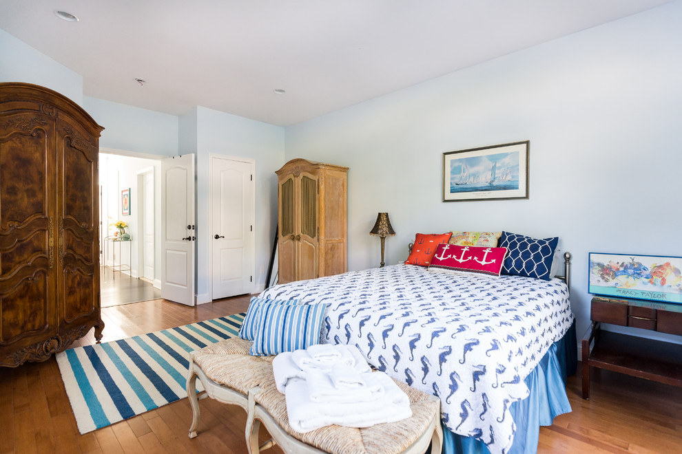 Foto på ett maritimt sovrum, med blå väggar och mellanmörkt trägolv