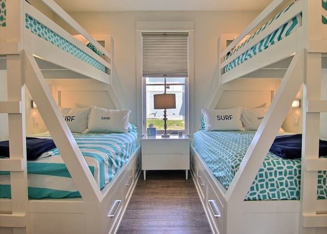 Design ideas for a small coastal guest bedroom in Austin with white walls, medium hardwood flooring and brown floors.