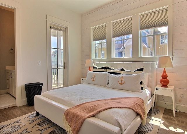 Inspiration for a mid-sized coastal guest medium tone wood floor and brown floor bedroom remodel in Austin with white walls