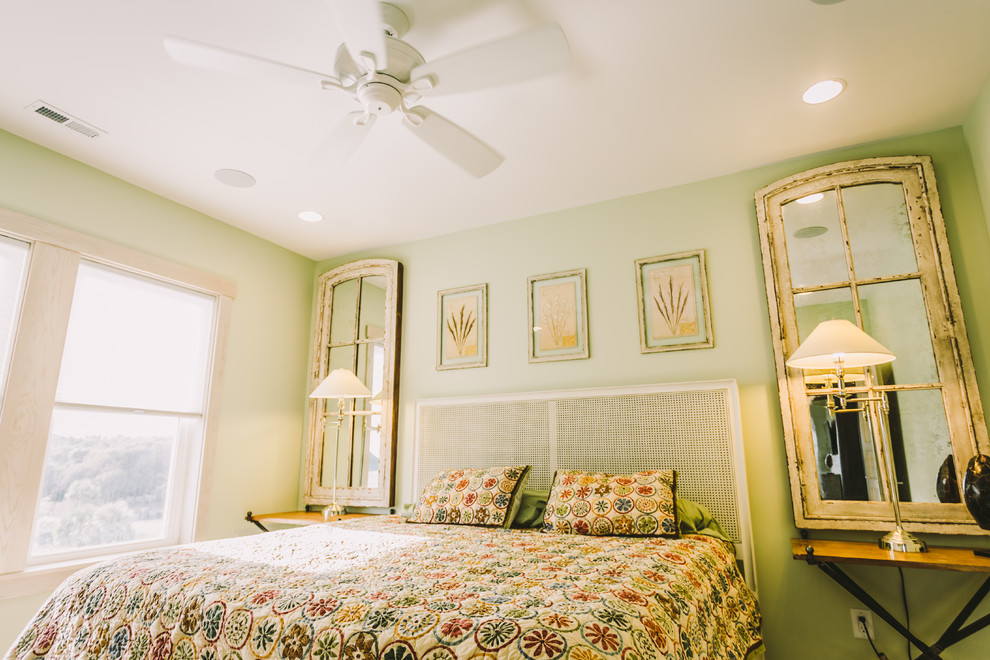 Imagen de habitación de invitados costera de tamaño medio sin chimenea con paredes verdes, suelo de madera en tonos medios y suelo marrón