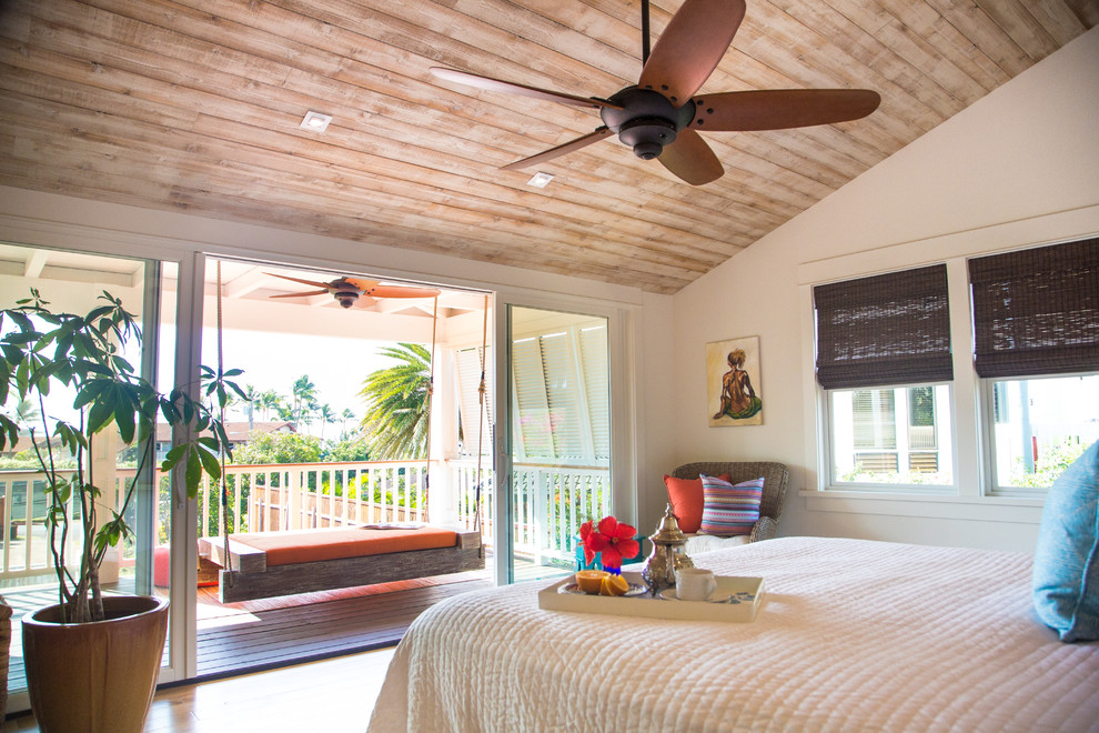 ハワイにある中くらいなビーチスタイルのおしゃれな主寝室 (白い壁、淡色無垢フローリング、暖炉なし、茶色い床) のインテリア