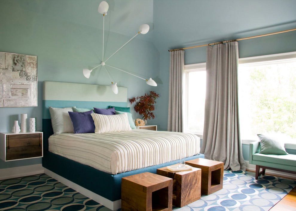 Imagen de dormitorio principal costero con paredes azules y suelo de madera en tonos medios