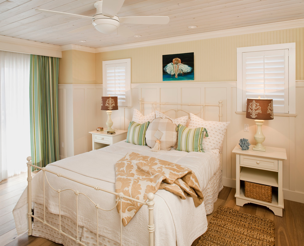 Idée de décoration pour une chambre parentale marine avec un mur beige et un sol en bois brun.