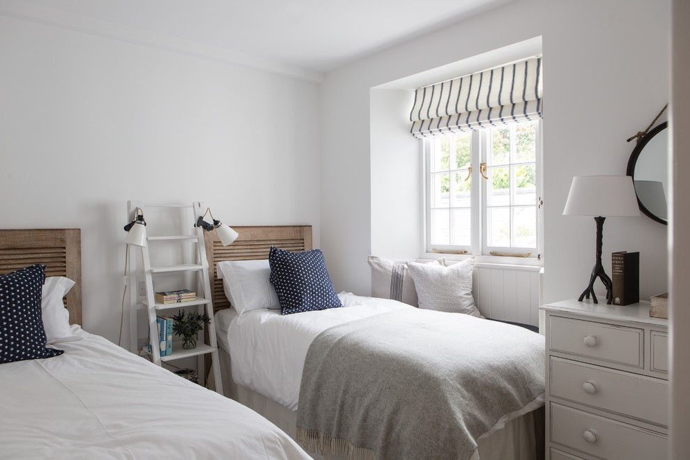 Design ideas for a beach style guest bedroom in London with white walls.
