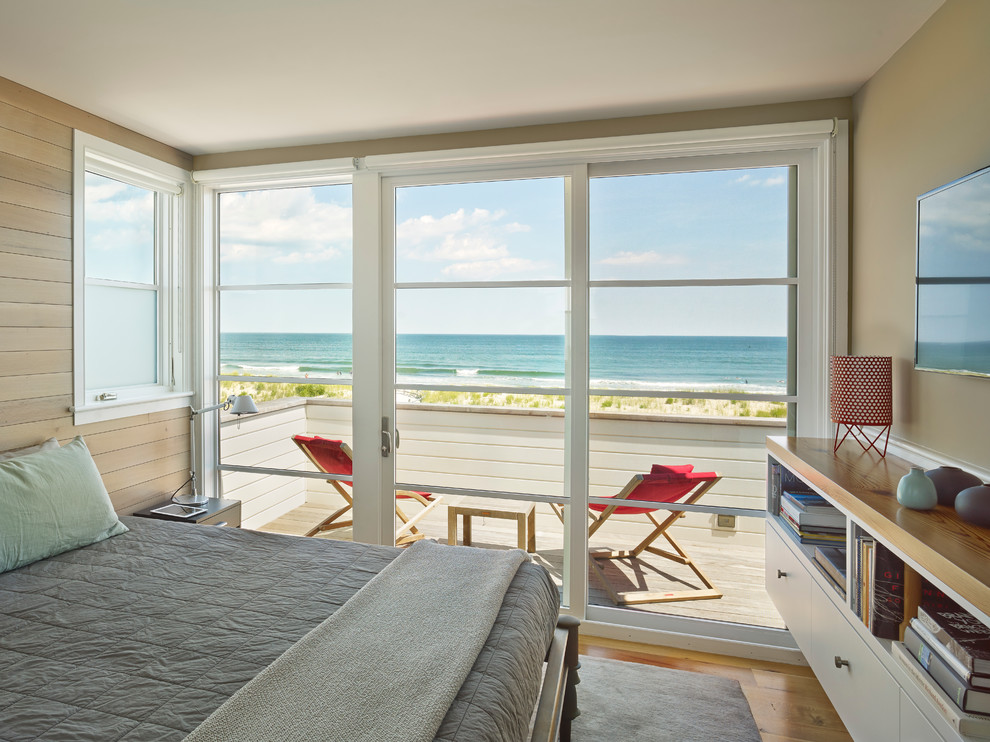 Imagen de dormitorio principal costero de tamaño medio con paredes beige y suelo de madera en tonos medios