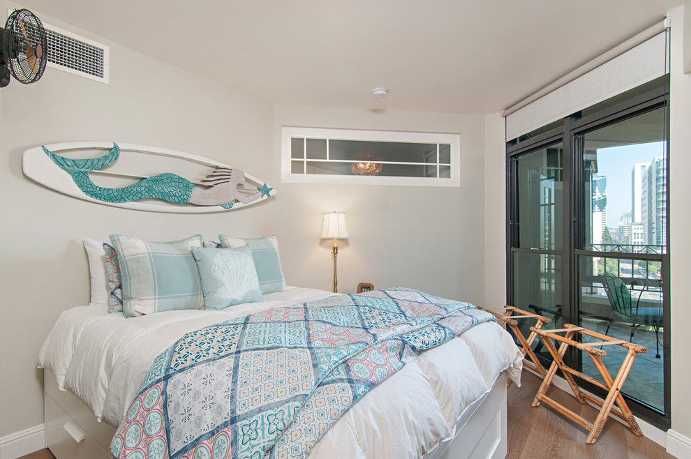 Kleines Maritimes Schlafzimmer mit weißer Wandfarbe, hellem Holzboden und Kaminumrandung aus Stein in San Diego