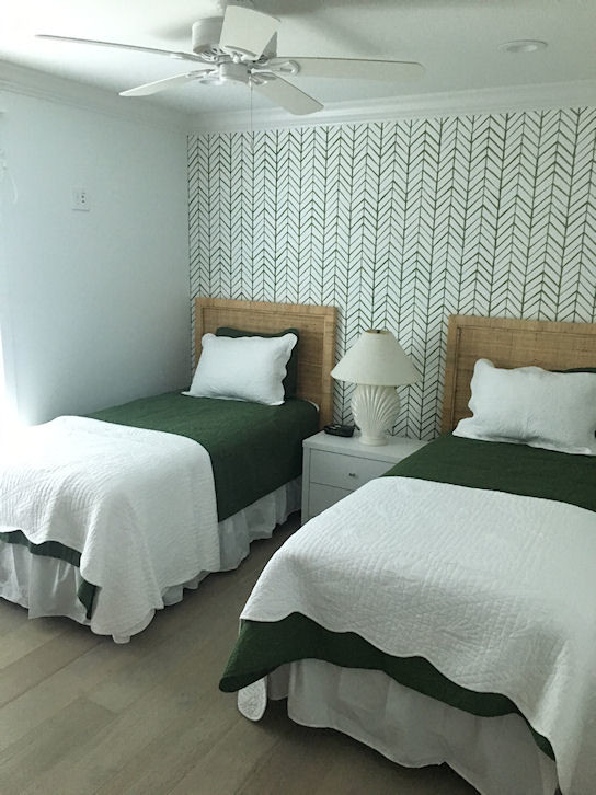 Immagine di una camera degli ospiti stile marino di medie dimensioni con pareti bianche, parquet chiaro, nessun camino e pavimento beige