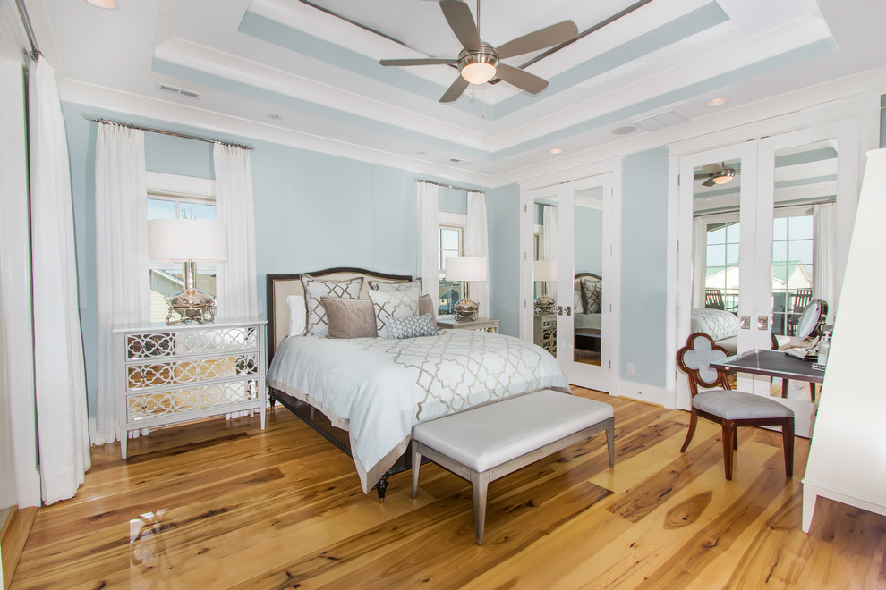 Imagen de habitación de invitados marinera de tamaño medio sin chimenea con paredes azules, suelo de madera en tonos medios y suelo beige