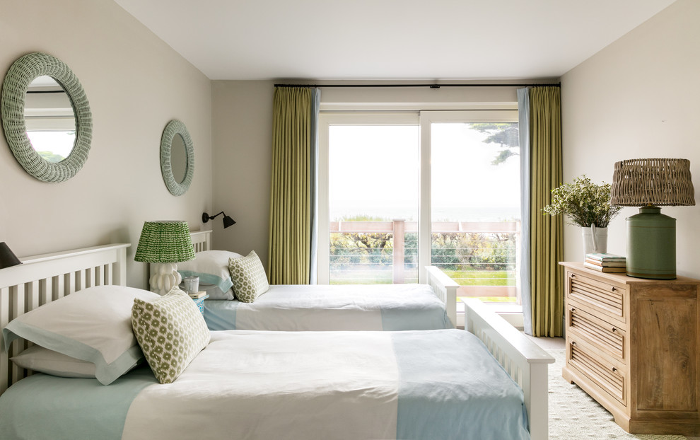 Design ideas for a medium sized beach style guest bedroom in Sussex with beige walls, beige floors and carpet.