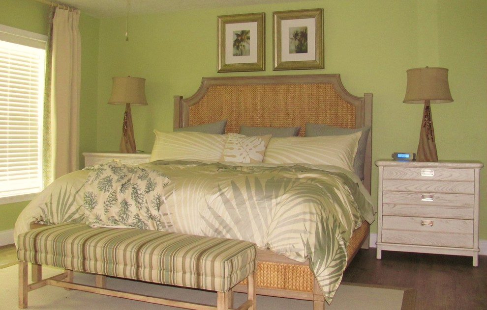 Immagine di una camera matrimoniale costiera di medie dimensioni con pareti verdi, pavimento in laminato e nessun camino