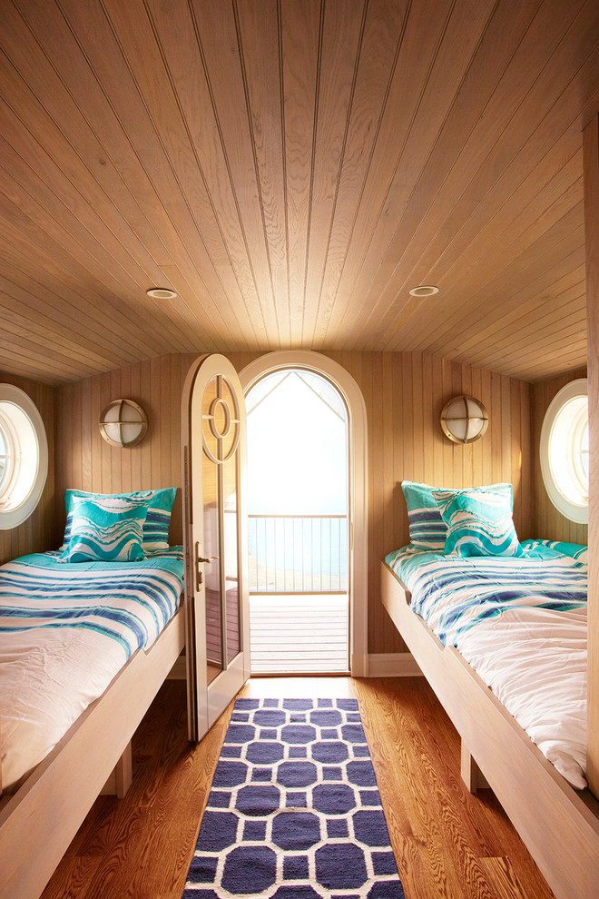 Diseño de dormitorio tipo loft costero de tamaño medio sin chimenea con paredes marrones, suelo de madera en tonos medios y suelo marrón