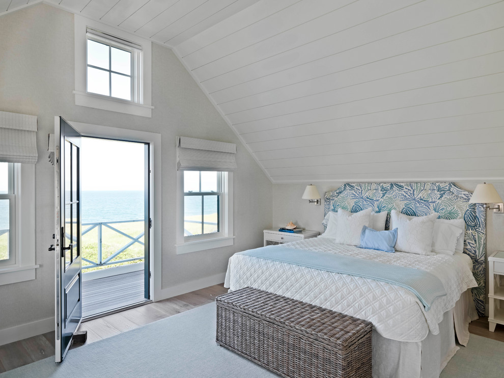 ボストンにある広いビーチスタイルのおしゃれな主寝室 (無垢フローリング、茶色い床、白い壁、暖炉なし、塗装板張りの天井、板張り壁、白い天井) のインテリア