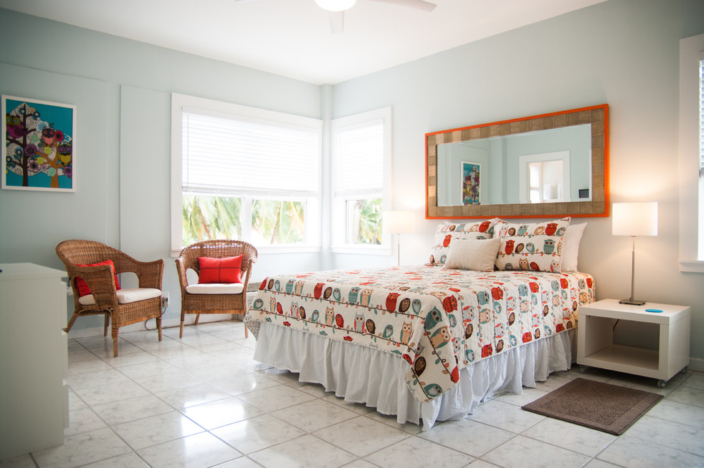 マイアミにある中くらいなモダンスタイルのおしゃれな客用寝室 (青い壁、セラミックタイルの床、暖炉なし)