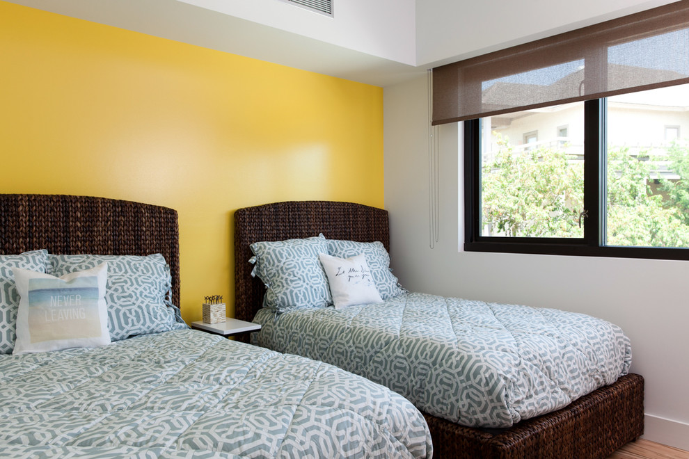 Cette photo montre une chambre d'amis moderne de taille moyenne avec un mur jaune et parquet clair.