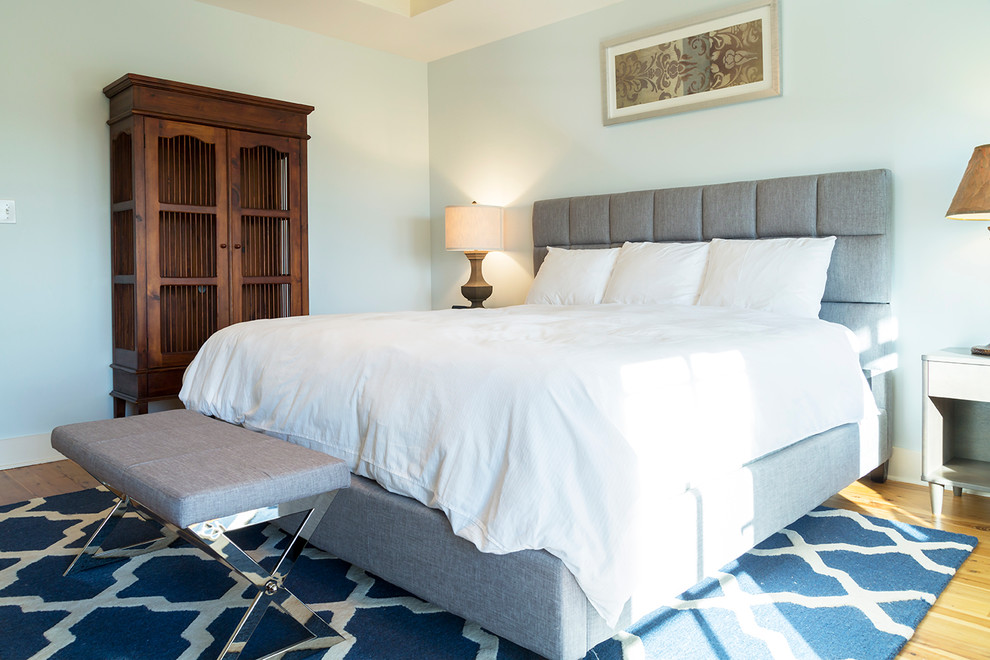 Diseño de dormitorio principal costero de tamaño medio con paredes azules y suelo de madera clara