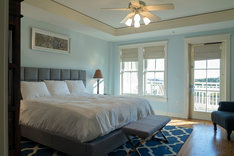 Diseño de dormitorio principal marinero de tamaño medio con paredes azules y suelo de madera clara