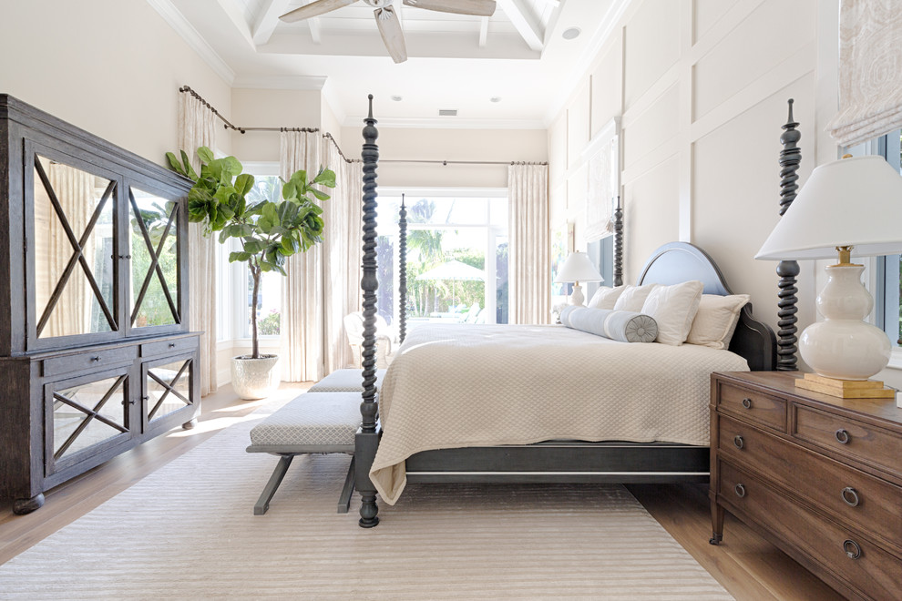 Bedroom - large coastal medium tone wood floor and brown floor bedroom idea in Miami with beige walls