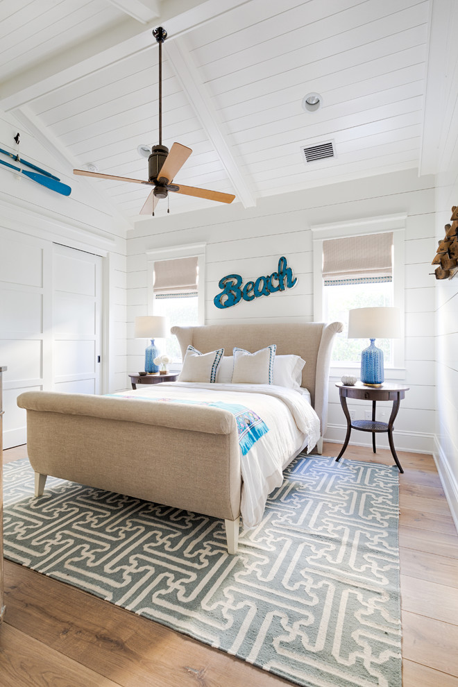 Maritimes Schlafzimmer mit weißer Wandfarbe, braunem Holzboden und braunem Boden in Miami