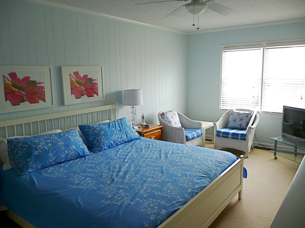 Diseño de dormitorio principal costero de tamaño medio sin chimenea con paredes azules y suelo de madera oscura