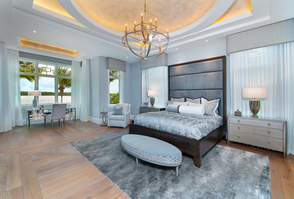 Example of a beach style master light wood floor bedroom design in Miami with blue walls and no fireplace