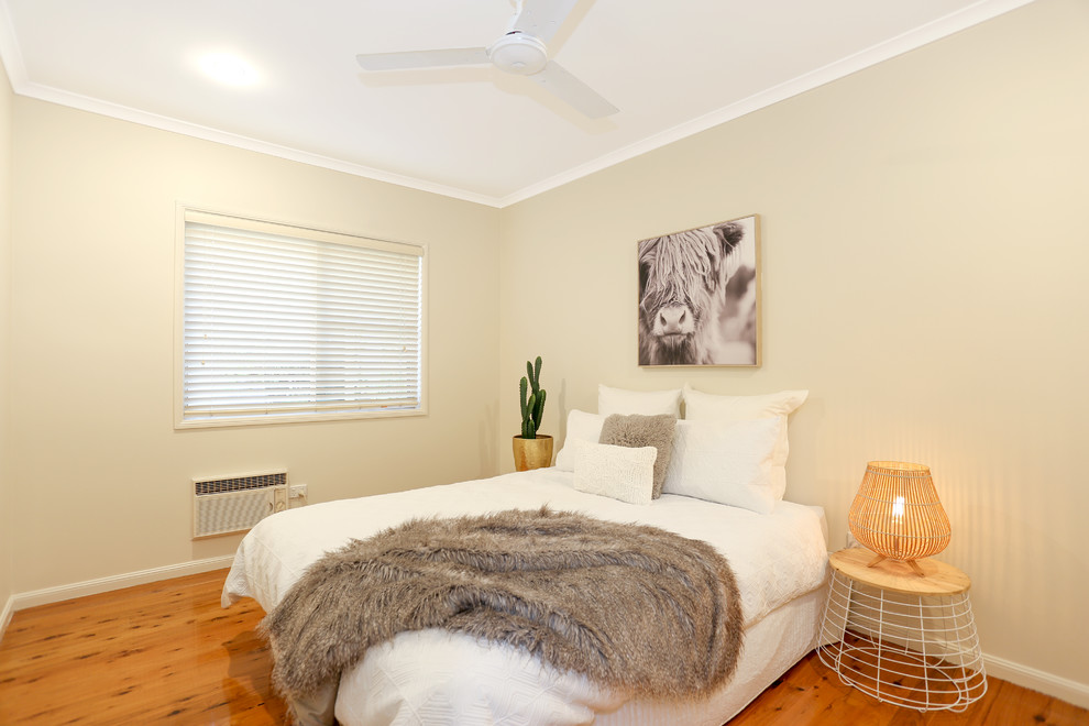 Maritimes Gästezimmer mit beiger Wandfarbe, braunem Holzboden und braunem Boden in Brisbane