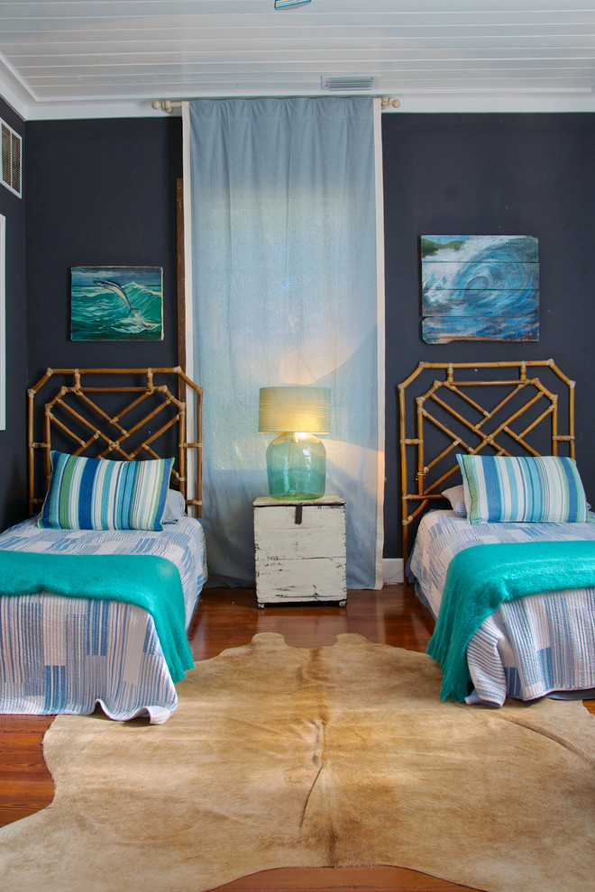 Cette image montre une chambre d'amis marine avec un mur bleu et un sol en bois brun.