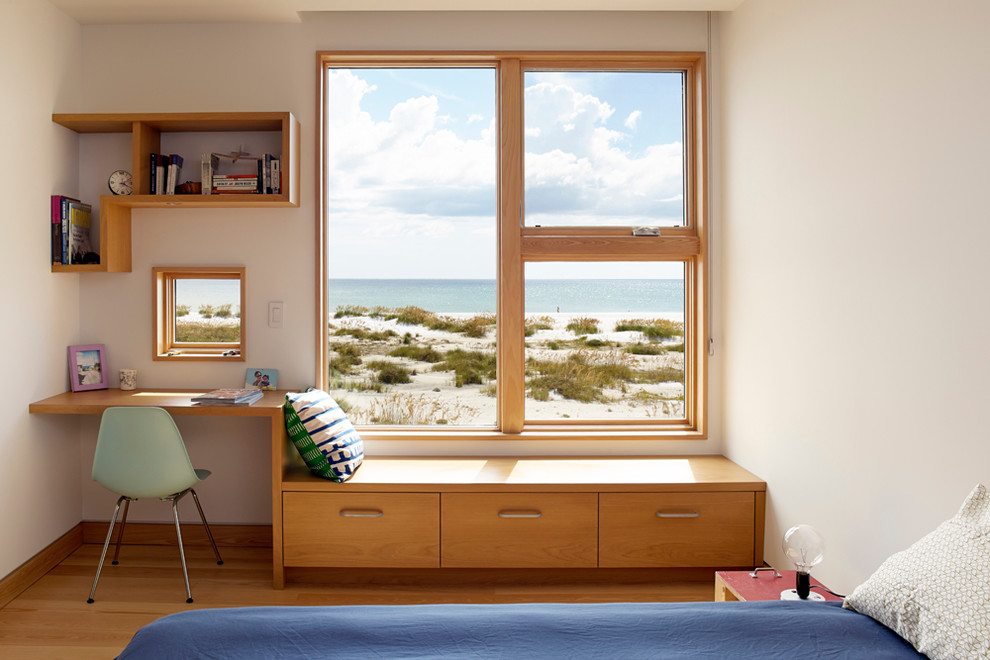 This is an example of a beach style guest bedroom in Tampa with white walls and medium hardwood flooring.