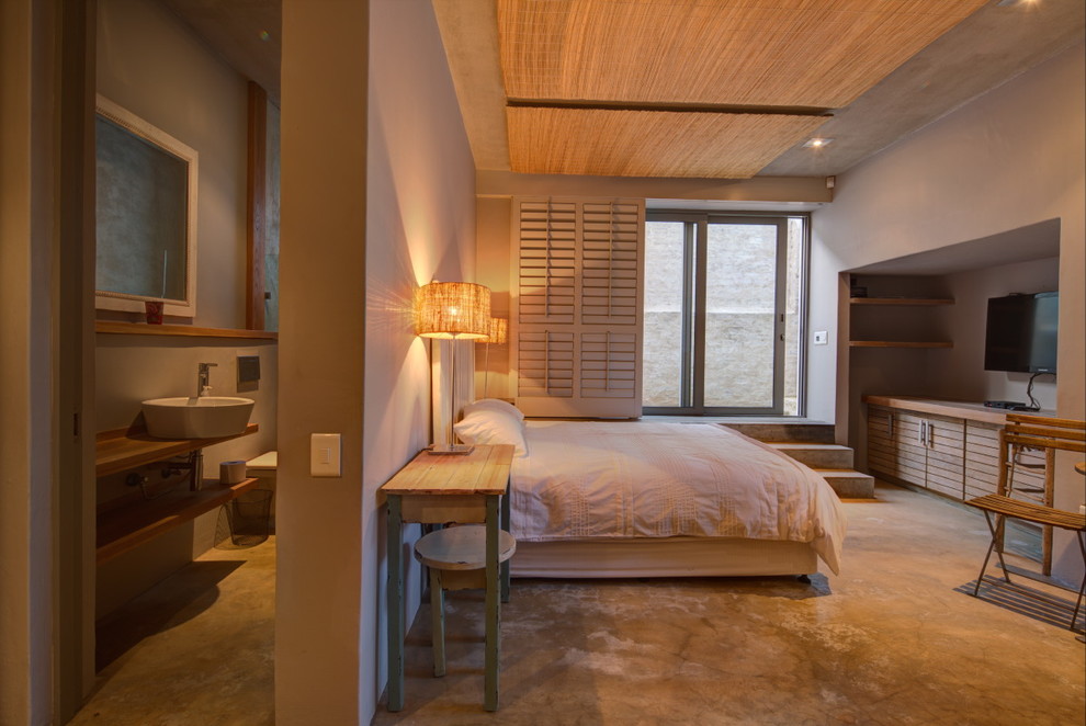 На фото: спальня в морском стиле с бетонным полом, серыми стенами и телевизором с