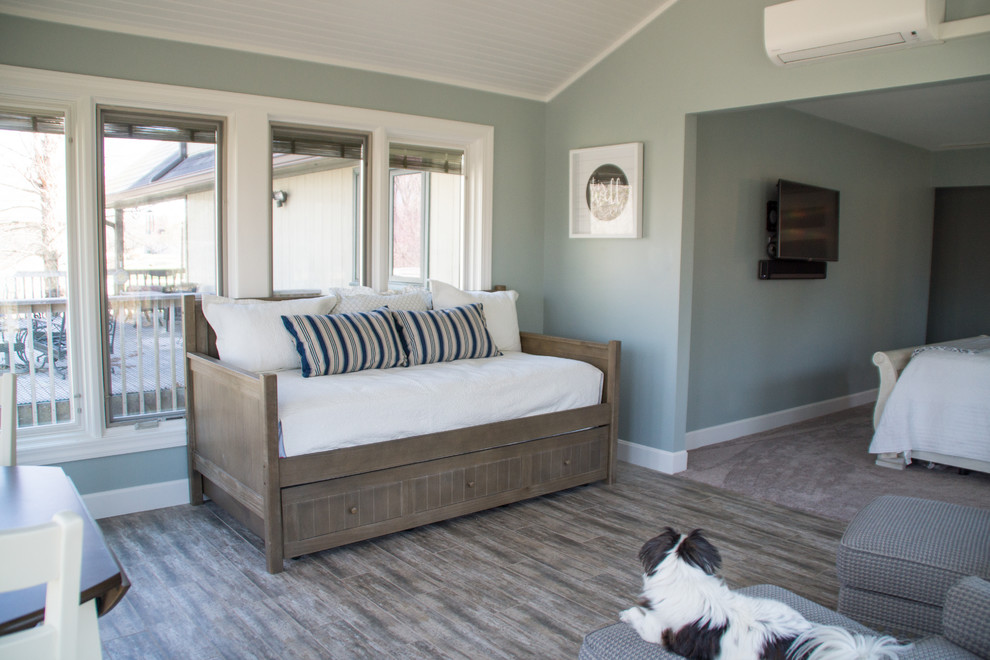Imagen de dormitorio principal costero grande sin chimenea con paredes verdes, suelo de baldosas de porcelana y suelo gris
