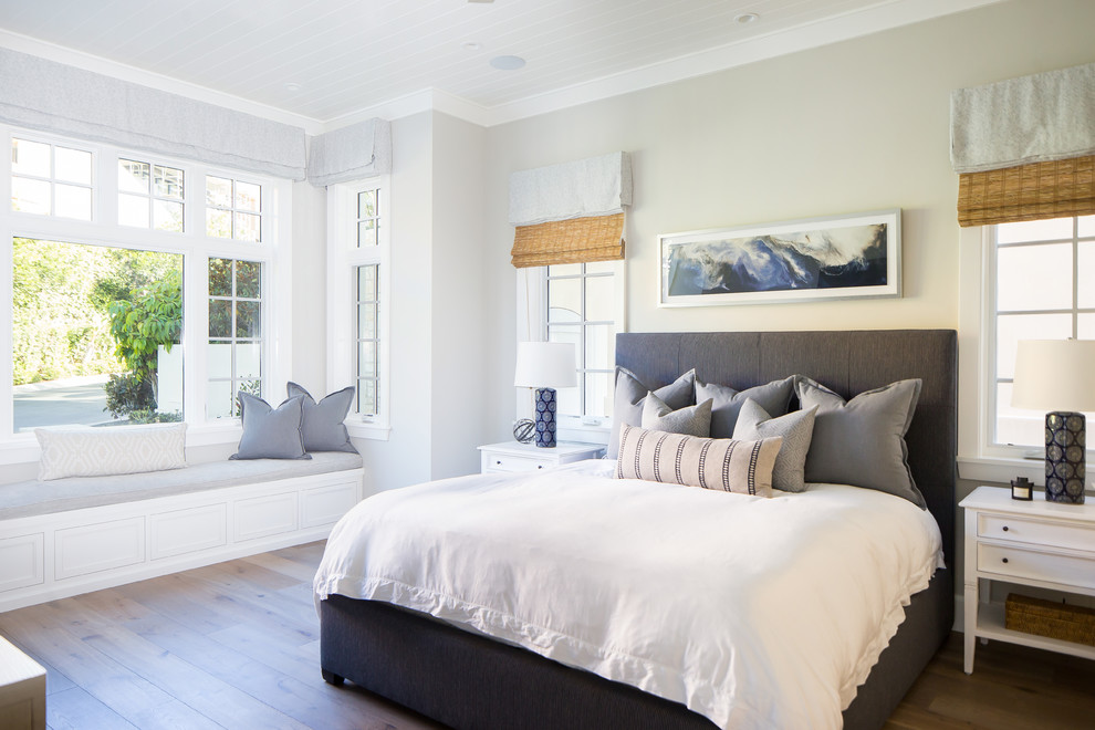 Maritimes Schlafzimmer mit beiger Wandfarbe, braunem Holzboden und braunem Boden in Orange County