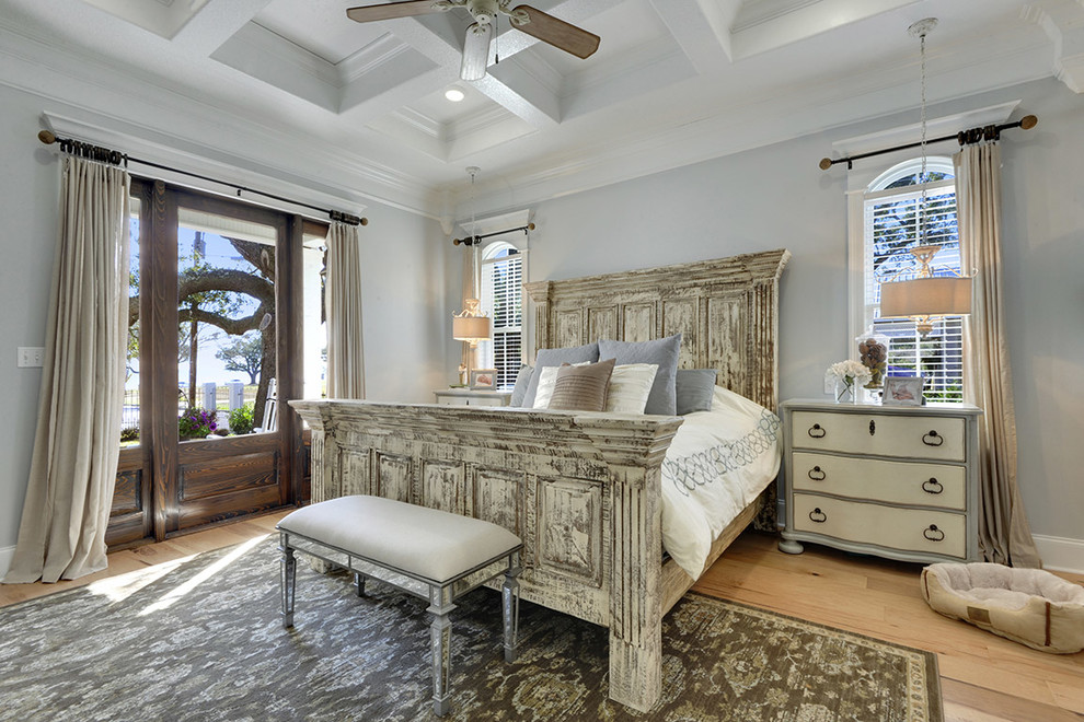 Foto de dormitorio principal costero grande con paredes grises y suelo de madera clara