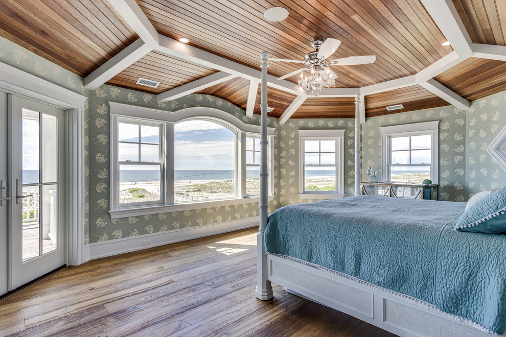 Design ideas for a large beach style master bedroom in Philadelphia with medium hardwood flooring and a standard fireplace.