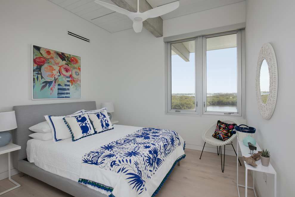 Modelo de habitación de invitados marinera de tamaño medio sin chimenea con paredes blancas, suelo de madera clara y suelo beige
