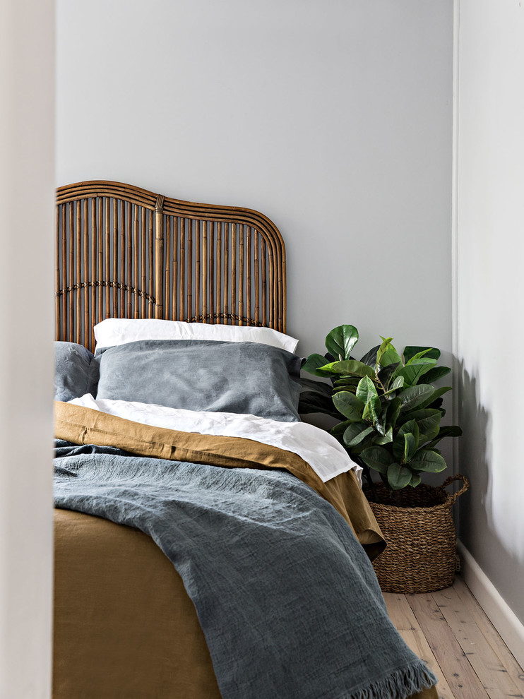 Modelo de dormitorio principal marinero de tamaño medio con paredes grises, suelo de madera clara y suelo beige