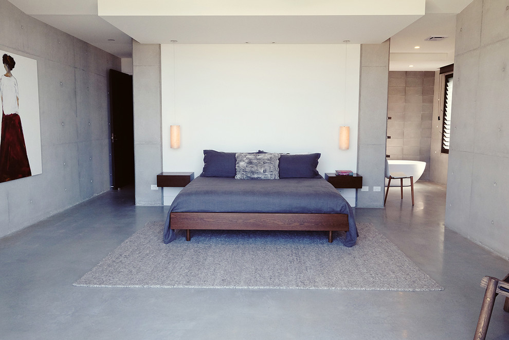 На фото: большая хозяйская спальня в современном стиле с серыми стенами и бетонным полом без камина