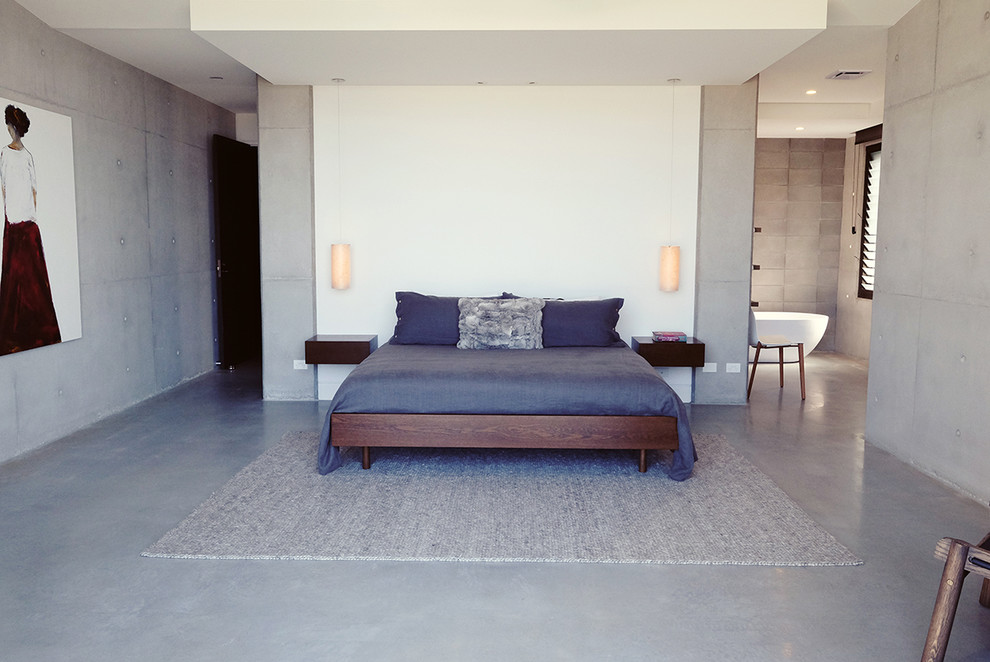 Aménagement d'une grande chambre parentale contemporaine avec un mur gris, sol en béton ciré et aucune cheminée.