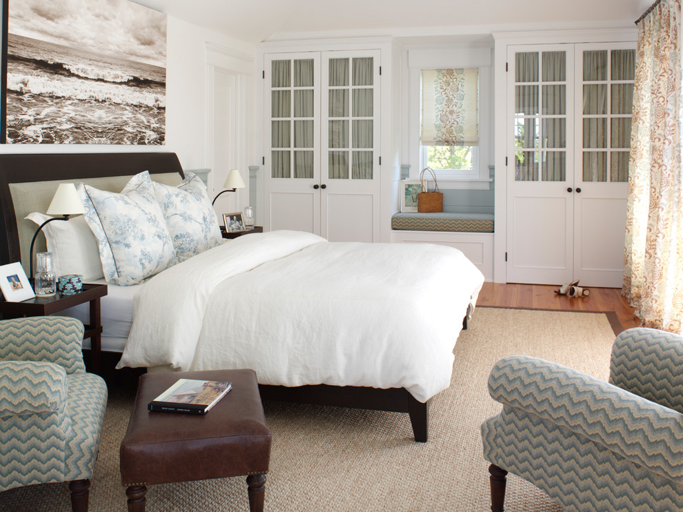 Foto de dormitorio principal costero de tamaño medio sin chimenea con paredes blancas, suelo de madera en tonos medios y suelo marrón