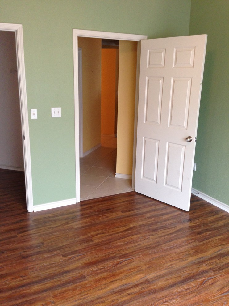 Mittelgroßes Hauptschlafzimmer mit grüner Wandfarbe und braunem Holzboden in Tampa