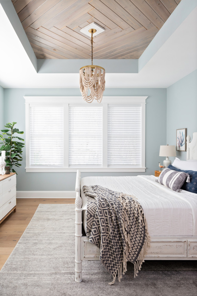 タンパにある中くらいなビーチスタイルのおしゃれな主寝室 (青い壁、無垢フローリング、ベージュの床、板張り天井)