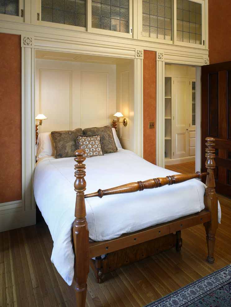 Bedroom - mid-sized traditional guest medium tone wood floor bedroom idea in Boston with orange walls