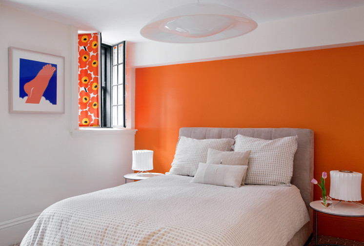 Modelo de dormitorio minimalista con parades naranjas y moqueta