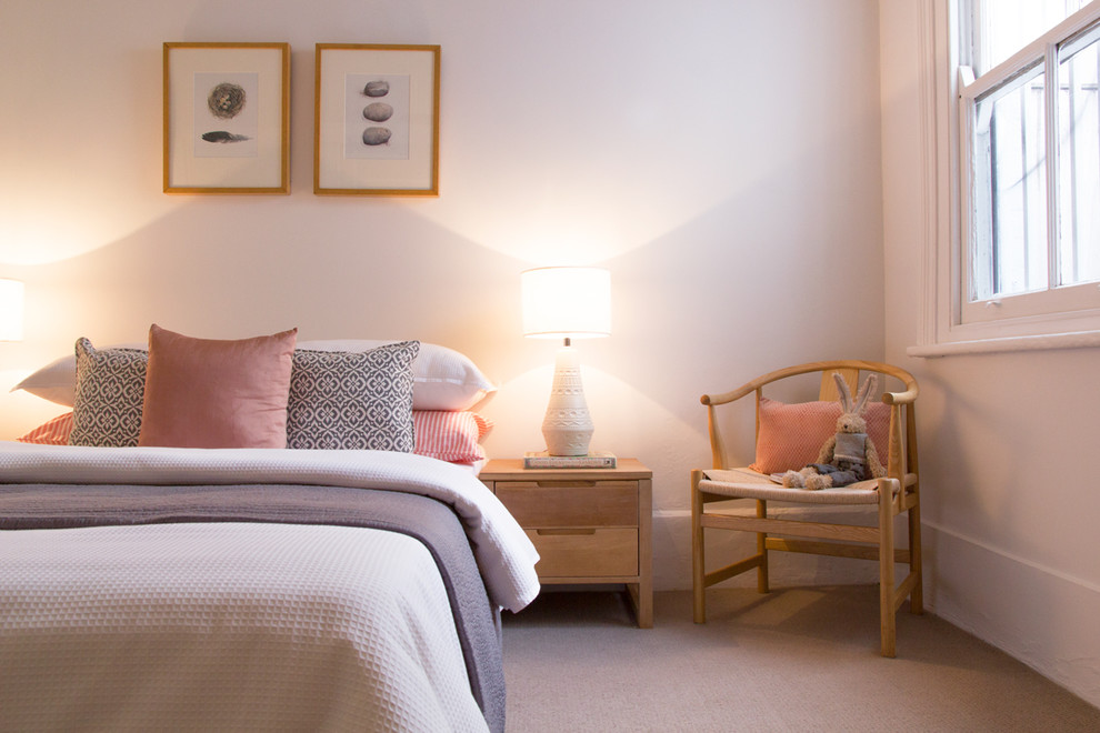 Foto på ett skandinaviskt sovrum, med vita väggar och heltäckningsmatta