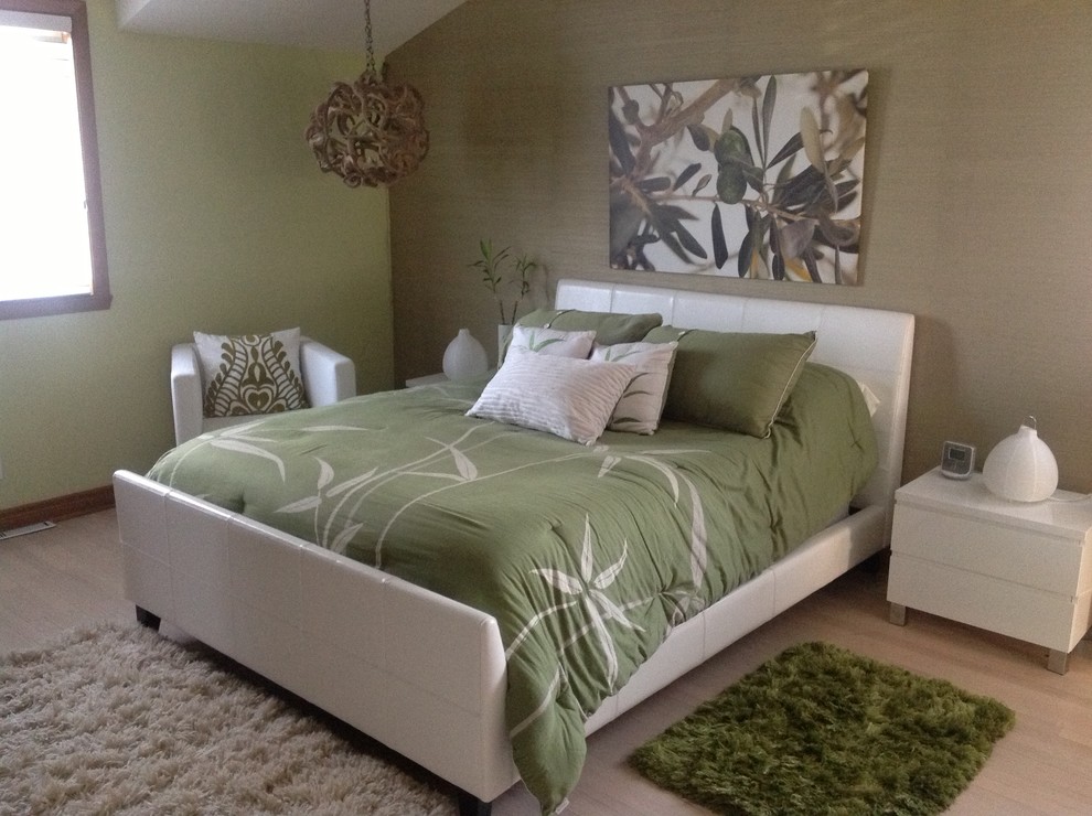 Large contemporary bedroom in Montreal with green walls, light hardwood flooring and no fireplace.