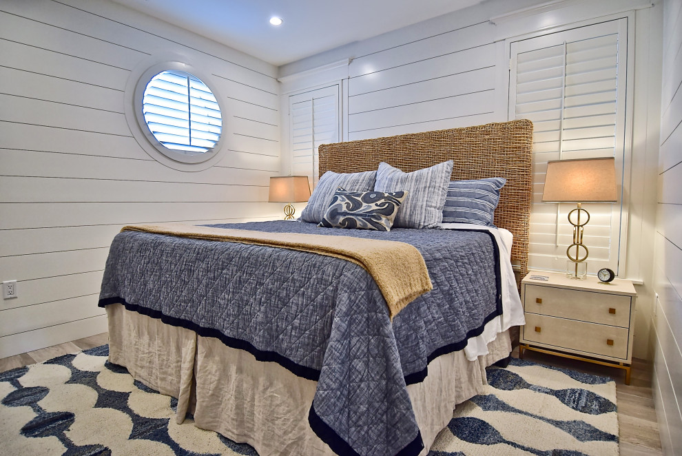 Cette image montre une petite chambre d'amis marine avec un mur blanc, un sol en carrelage de porcelaine et un sol beige.