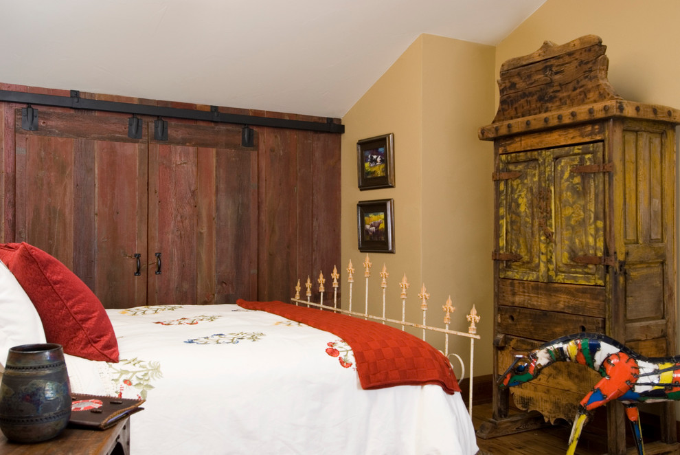 Photo of a rustic bedroom in Other with beige walls and dark hardwood flooring.